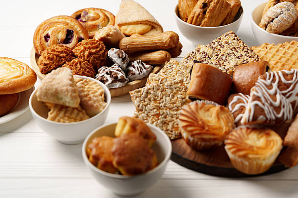 Assortment of baked treats displayed on wooden boards and white bowls for a delightful dessert experience