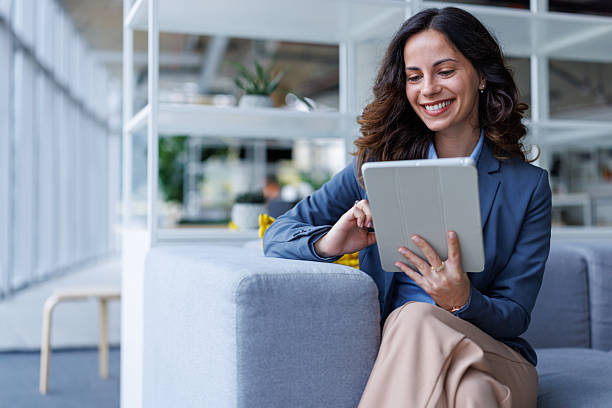 istock Businesswoman smiling while using digital tablet in modern office 2245292460