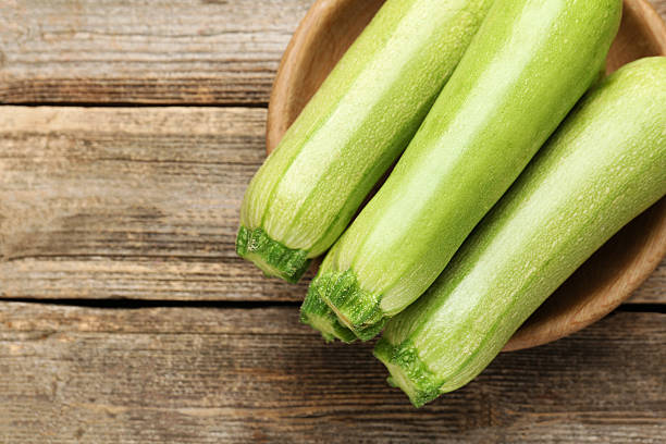 istock Fresh ripe zucchinis on wooden table, top view. Space for text 2245292505