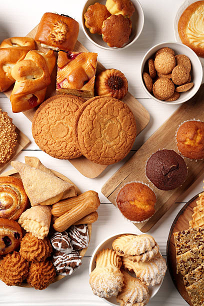 istock Assorted baked goods displayed on a wooden table, featuring cookies, pastries, and muffins in a cozy setting 2245292662