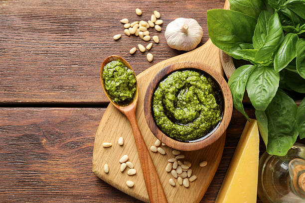 istock Fresh pesto sauce and ingredients on wooden table, flat lay. Space for text 2245293200