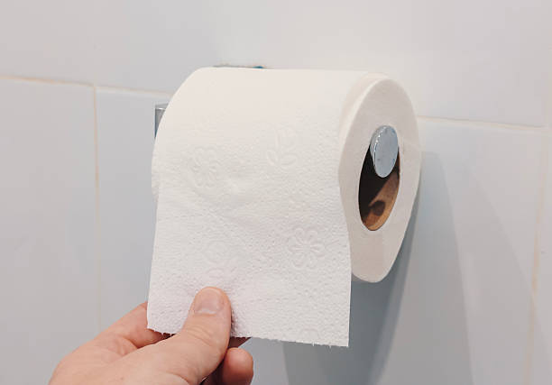 istock A hand pulls a sheet of toilet paper from a roll mounted on the wall in a bathroom 2245296058