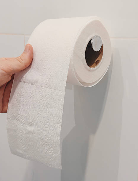 istock A hand pulls a sheet of toilet paper from a roll mounted on the wall in a bathroom 2245296143