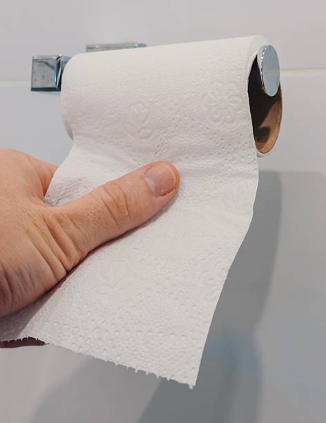 istock A hand pulls a sheet of toilet paper from a roll mounted on the wall in a bathroom 2245296333