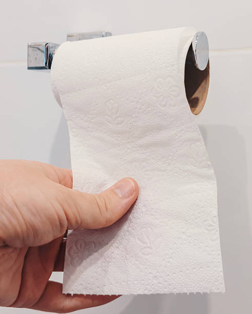 istock A hand pulls a sheet of toilet paper from a roll mounted on the wall in a bathroom 2245296408