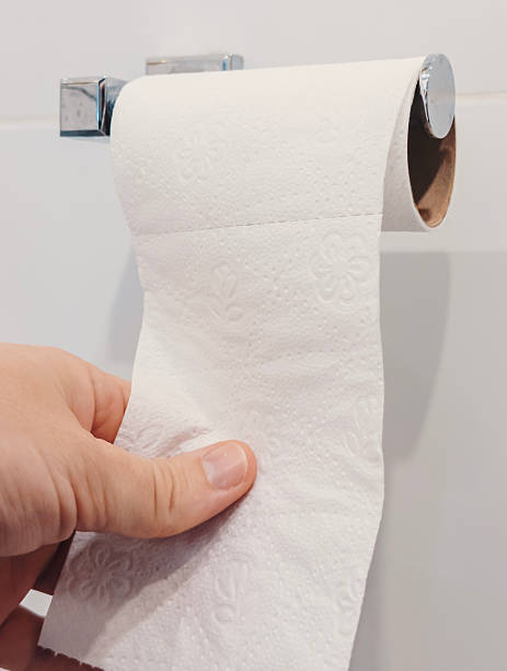 istock A hand pulls a sheet of toilet paper from a roll mounted on the wall in a bathroom 2245296440