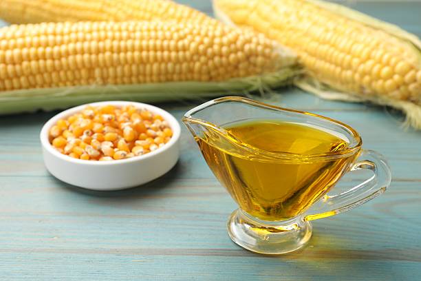 istock Corn oil, kernels and cobs on blue wooden table, closeup 2245298302