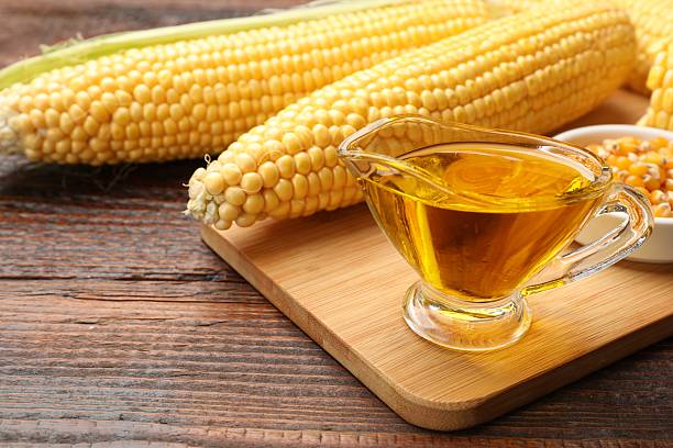 istock Corn oil, kernels and cobs on wooden table, closeup 2245298409