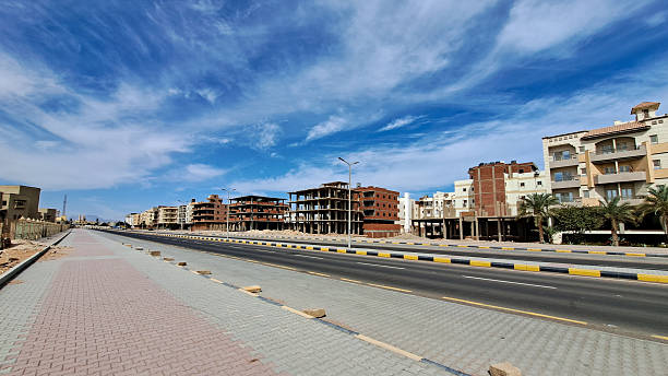 istock Urban landscape featuring modern architecture and construction sites alongside a wide road, showcasing a vibrant city development under a clear blue sky. Hurghada, Egypt, Red Sea 2245299093