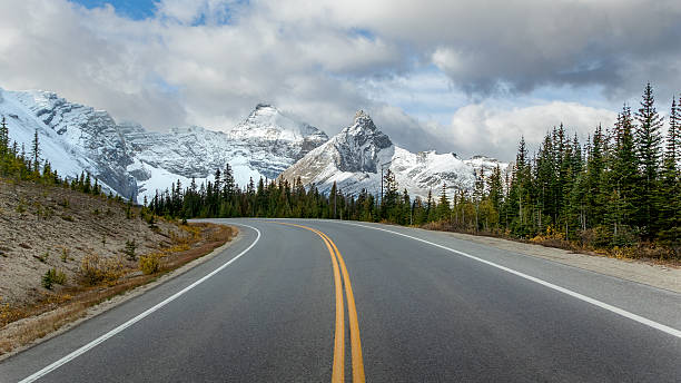 istock Empty highway curving toward snowy mountains on Icefields Parkway, Alberta 2245299787