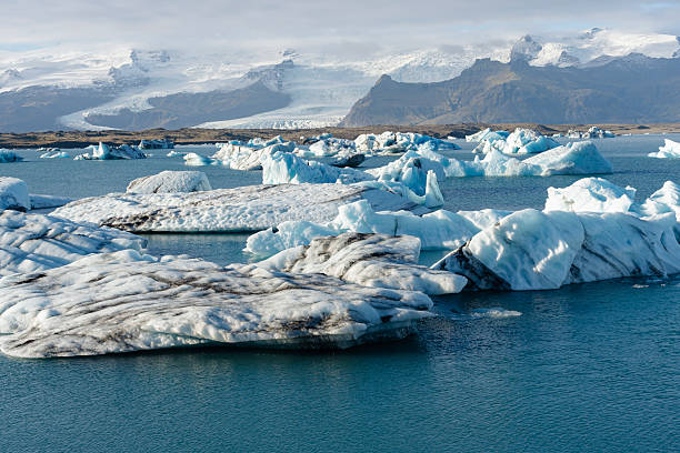 istock Floating icebergs in a glacial lagoon, set against snowy mountains. 2245301003
