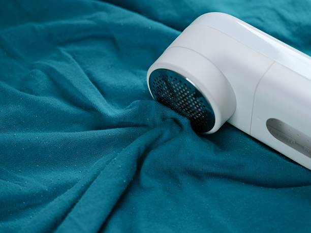 istock Portable lint remover lying on a blue clothes. 2245301531