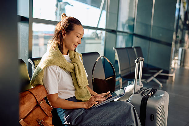 Woman using tablet waiting at airport terminal