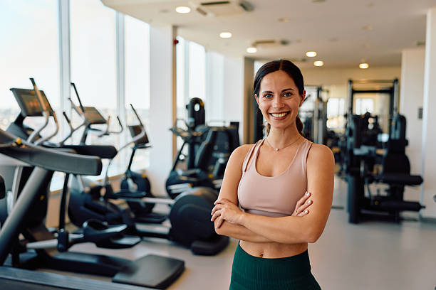 istock Smiling woman standing confidently in modern gym 2245303101