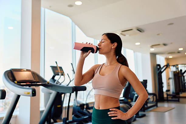 istock Woman drinking water bottle hydrating during gym workout 2245303168
