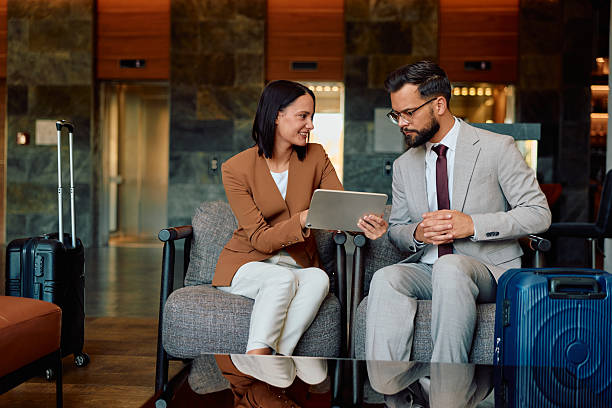 istock Business colleagues discussing project with tablet in hotel lobby 2245303270