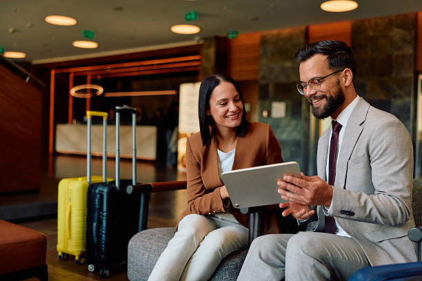 istock Business colleagues discussing work using digital tablet in hotel lobby 2245303462