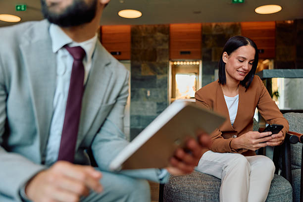 istock Business colleagues waiting in modern lobby using digital devices 2245303493