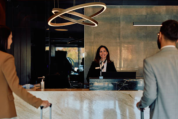 istock Hotel receptionist welcoming business couple for check-in 2245303517