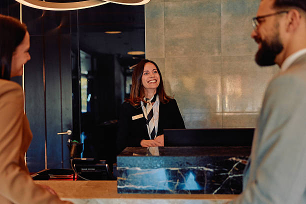 istock Hotel reception checking in guests receiving welcome service 2245303519