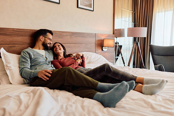 istock Happy couple relaxing on bed during romantic hotel weekend getaway 2245303531