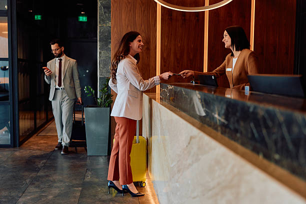 istock Woman checking into a hotel, receiving key card from receptionist 2245303563