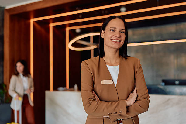 istock Smiling hotel receptionist welcoming guests in lobby 2245303593