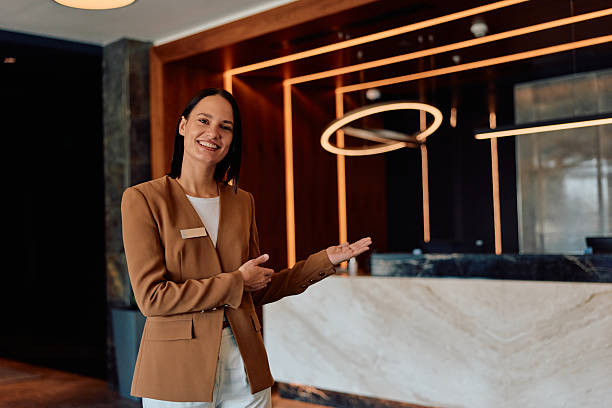 istock Smiling hotel receptionist welcoming guests at luxury lobby 2245303605
