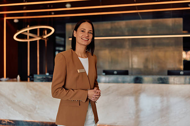 istock Hotel receptionist welcoming guests at front desk 2245303630