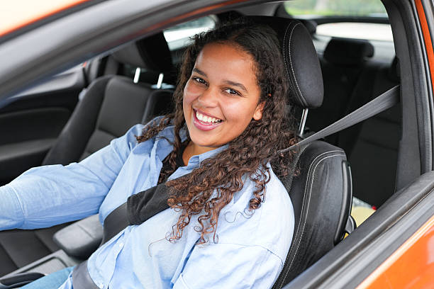istock Happy young african woman smiling on camera while sitting inside a car - Driving license, lifestyle and insurance concept - Focus on face 2245305241