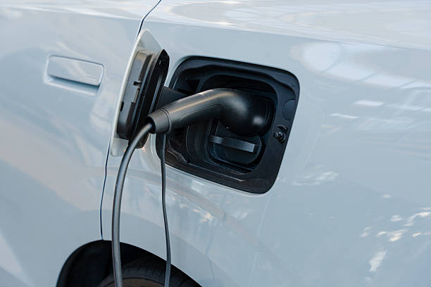 istock Close-up of a white electric car charging with a black charging cable. 2245306063