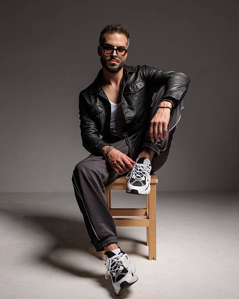 istock sexy bearded man with sunglasses holding elbow on knee and sitting 2245306949