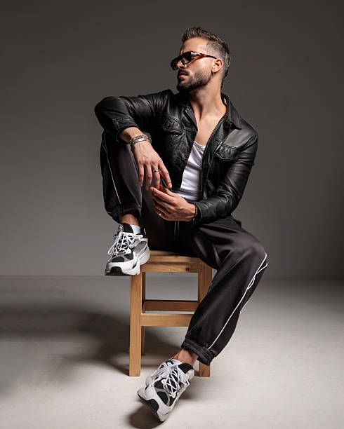 istock unshaved cool man holding elbow on knee and looking to side 2245307739