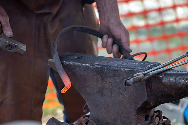 istock Blacksmith working with glowing coals and metal tools at outdoor forge 2245307836