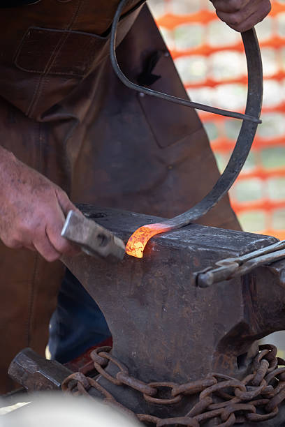 istock Blacksmith working with glowing coals and metal tools at outdoor forge 2245307841