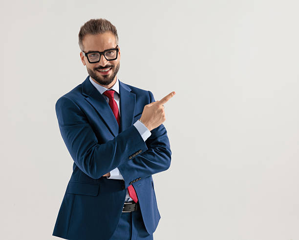 istock bearded elegant man with glasses smiling and pointing finger to side 2245308053