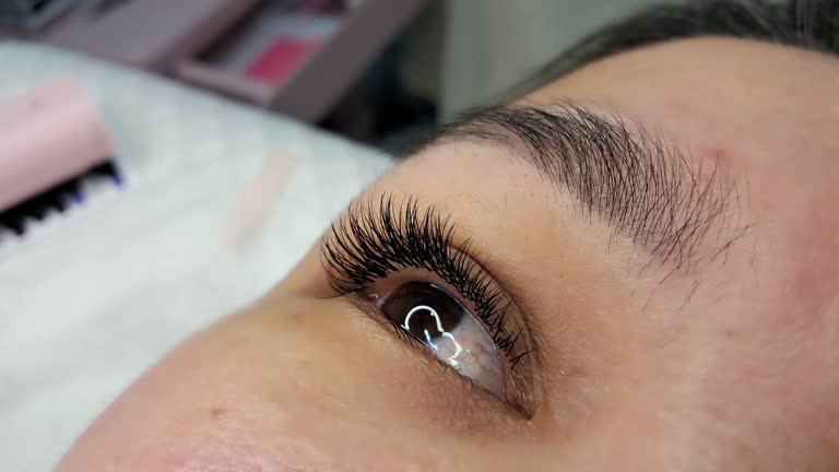 Close up of female eye with eyelash extensions ,eyelash extension procedure.2d volume,