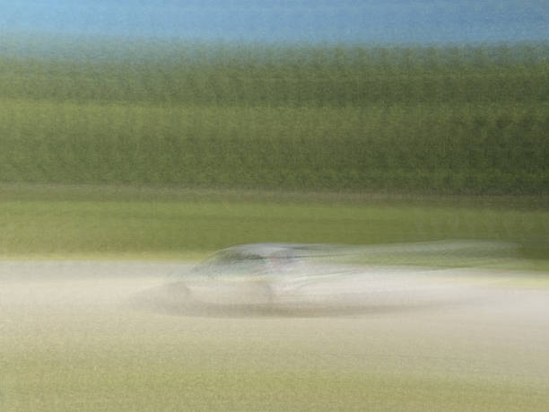 Low angle view of a generic red sports car travelling at speed through a tunnel early in the morning or late in the day. The car has it's headlights on and there is no other traffic on the road.