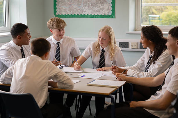 istock Happy looking high school students working together as a group in a classroom 2245310038