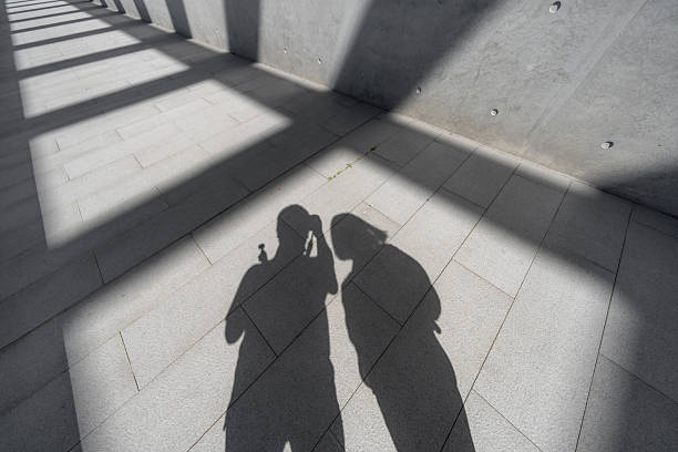 The shadows of two people on the concrete floor