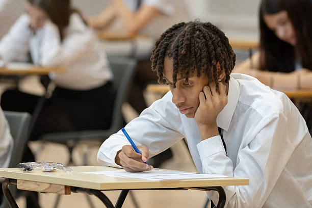 istock Male high school student sitting an exam in a large hall 2245310343
