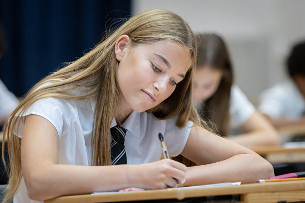 istock Confident high school student sitting an exam in a large hall 2245311324