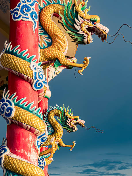 istock Intricately carved dragons adorn vibrant pillars under a cloudy sky 2245311913