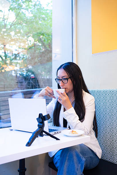 istock Young woman drinking coffee working online in cafe 2245312728