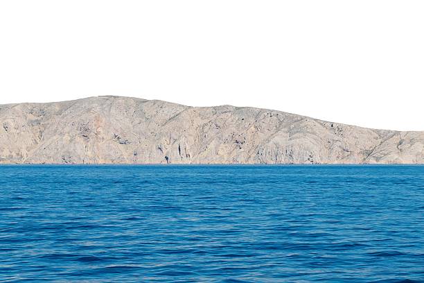 Majestic rocky island with clear blue ocean. Isolated object on white background.