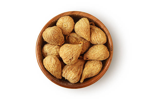 Dried figs in wooden bowl on white background