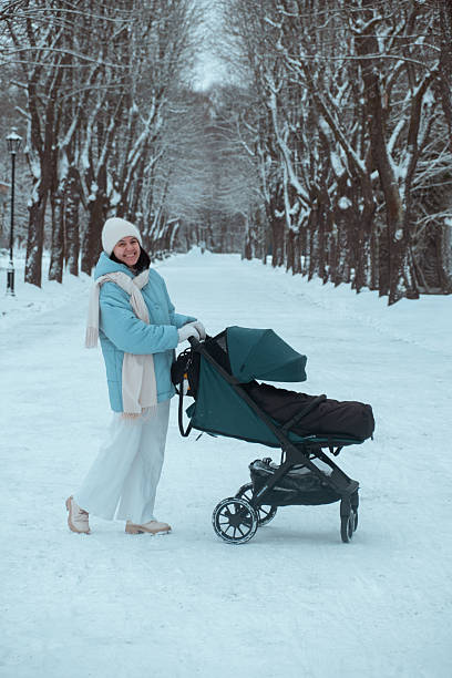 istock Winter Stroll with Stroller in Snowy Park 2245318671
