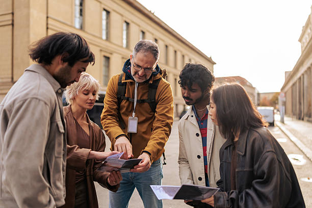 istock Tour Guide And Tourists Looking At Berlin City Map 2245319470