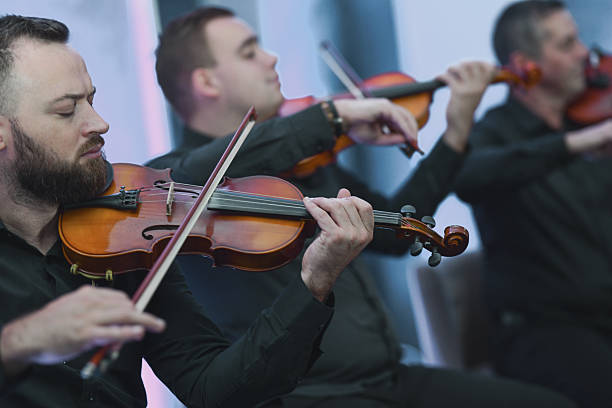 istock Violinists Playing in a Live Ensemble Session With Focused Expressions 2245319500