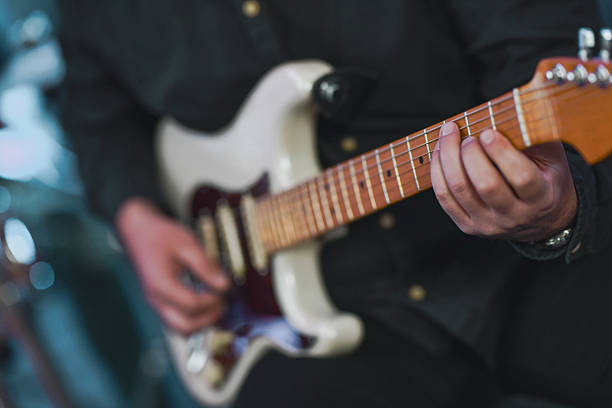 istock Guitarist In Black Plays White Electric Guitar During Live Studio Session 2245319657